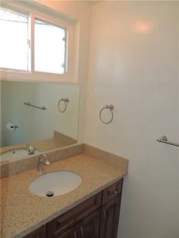 a bathroom with a granite countertop sink and a mirror