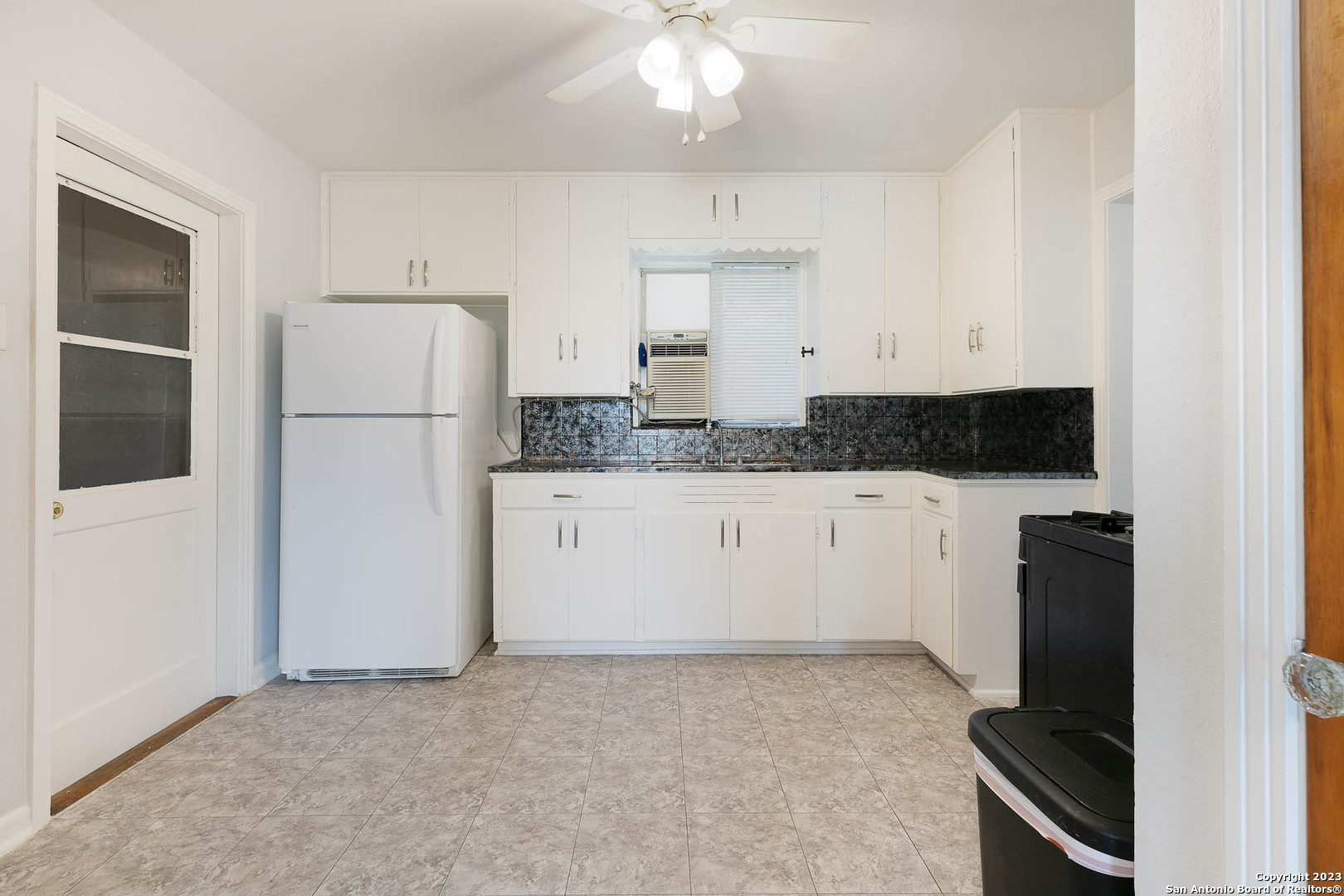 463 Cherry Ridge San Antonio, TX 78213 - Photo 7 of 19 a kitchen with granite countertop white cabinets and white appliances