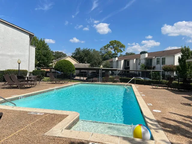 a view of a swimming pool with a patio and plants