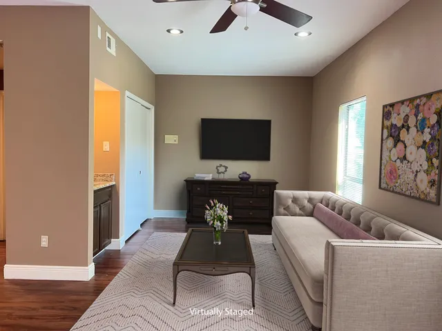 a living room with furniture and a flat screen tv with wooden floor
