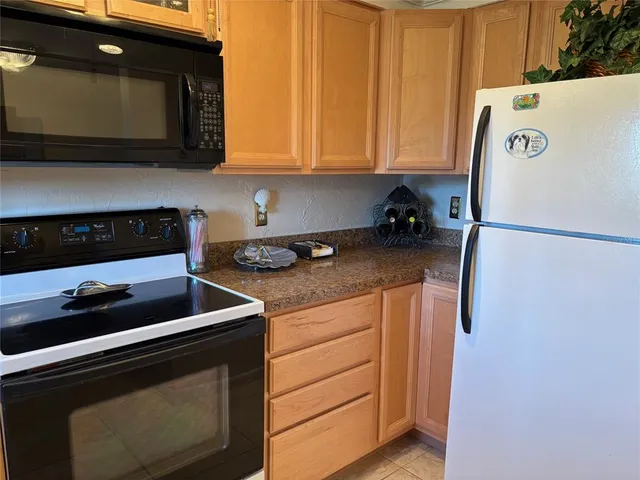 a kitchen with stainless steel appliances granite countertop a refrigerator stove and microwave