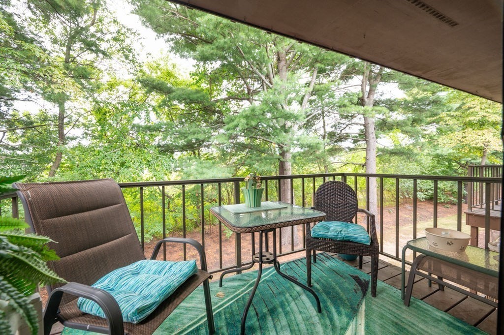 147 Sylvan Street, Unit 18B Danvers, MA 01923 - Photo 11 of 24 a balcony with wooden floor table and chairs