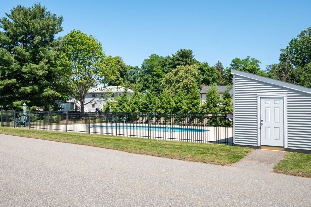 147 Sylvan Street, Unit 18B Danvers, MA 01923 - Photo 21 of 24 a view of a house with a big yard and palm trees