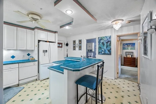 a kitchen with granite countertop appliances a sink and a refrigerator