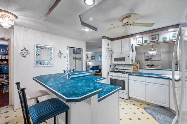 a kitchen with a stove a sink dishwasher a dining table and chairs with wooden floor