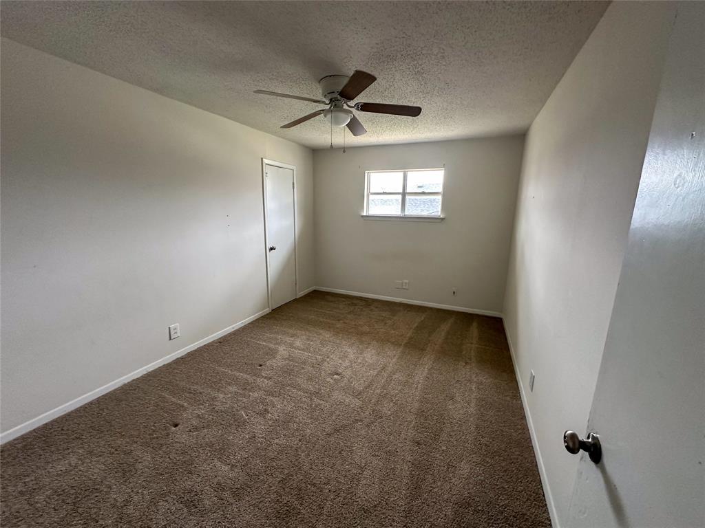 1016 West Gandy Street, Unit 4 Denison, TX 75020 - Photo 4 of 11 an empty room with a ceiling fan and window