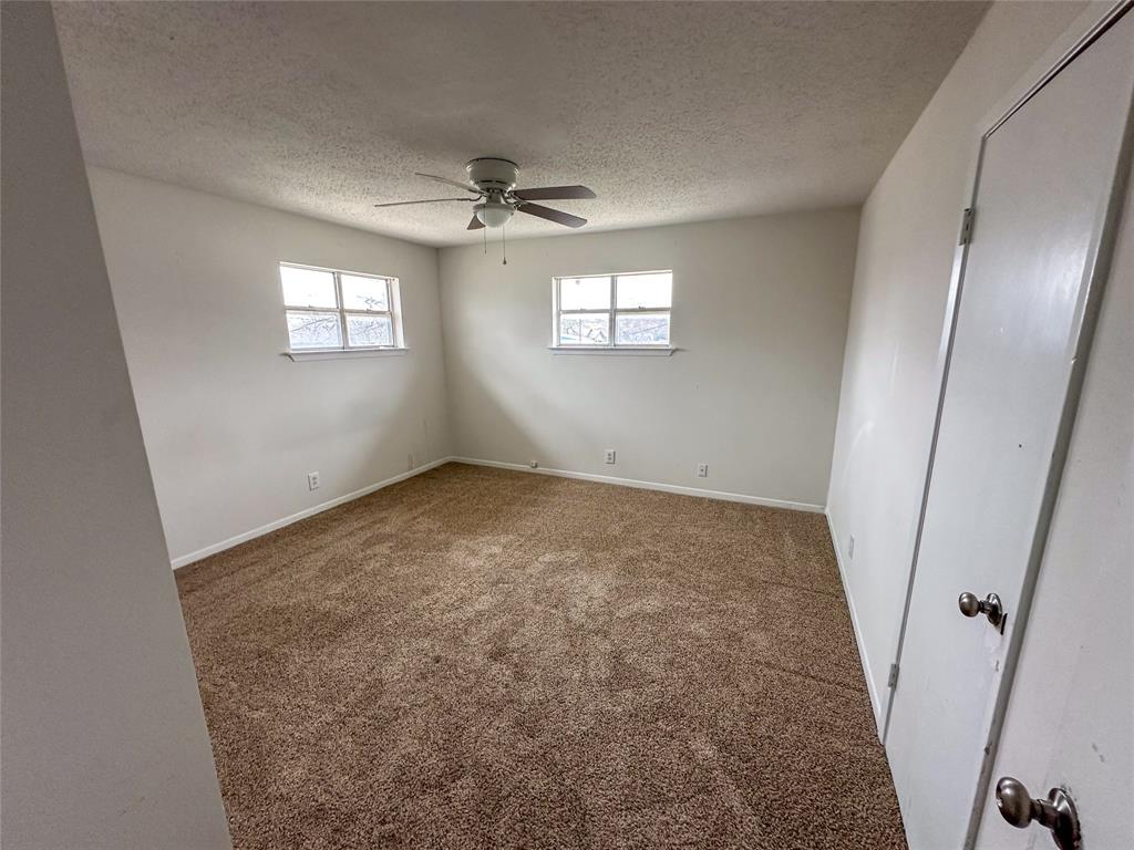 1016 West Gandy Street, Unit 4 Denison, TX 75020 - Photo 5 of 11 an empty room with windows and fan