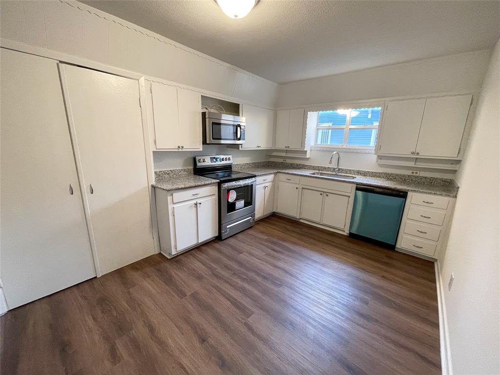 1016 West Gandy Street, Unit 4 Denison, TX 75020 - Photo 6 of 11 a kitchen with stainless steel appliances granite countertop a stove top oven a sink dishwasher and a refrigerator