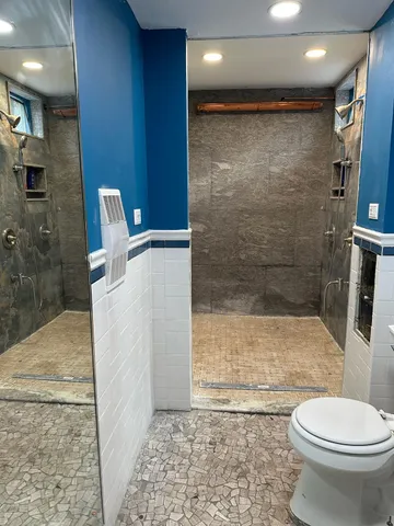 a bathroom with a toilet and a shower