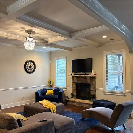 a living room with furniture a flat screen tv and a fireplace