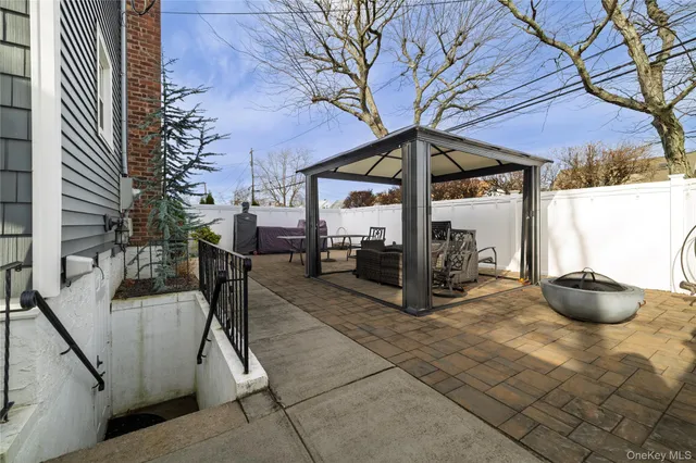 a view of chairs and tables in the back yard of the house