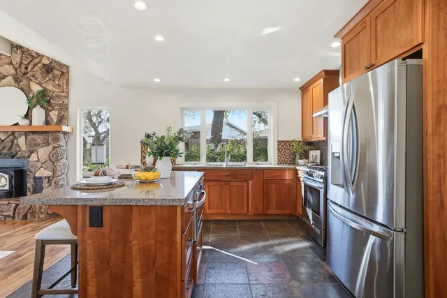 a kitchen with stainless steel appliances granite countertop a refrigerator and a stove top oven