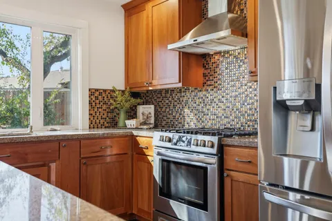 a living room with furniture a wooden floor and kitchen view