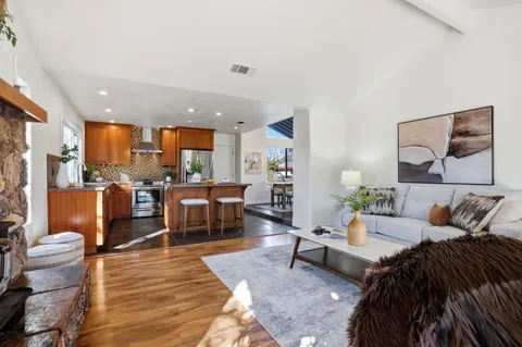 a living room with furniture a fireplace and a floor to ceiling window