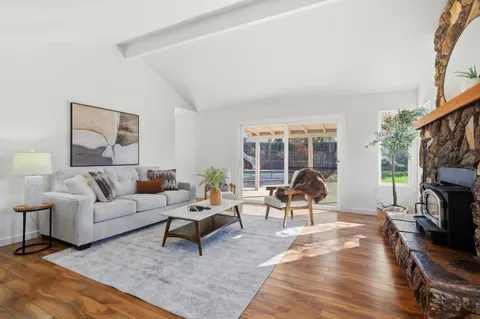 a living room with furniture a fireplace and a floor to ceiling window