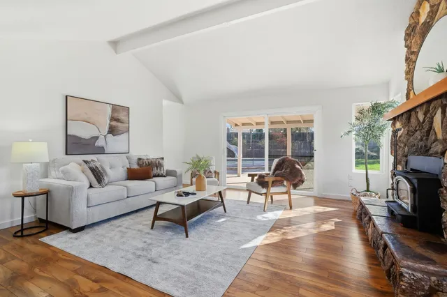 a living room with furniture a fireplace and a floor to ceiling window
