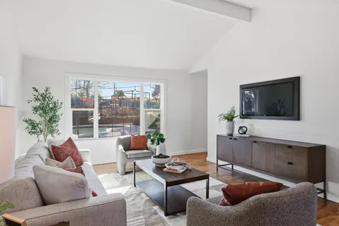 a view of a dining room with furniture and a potted plant