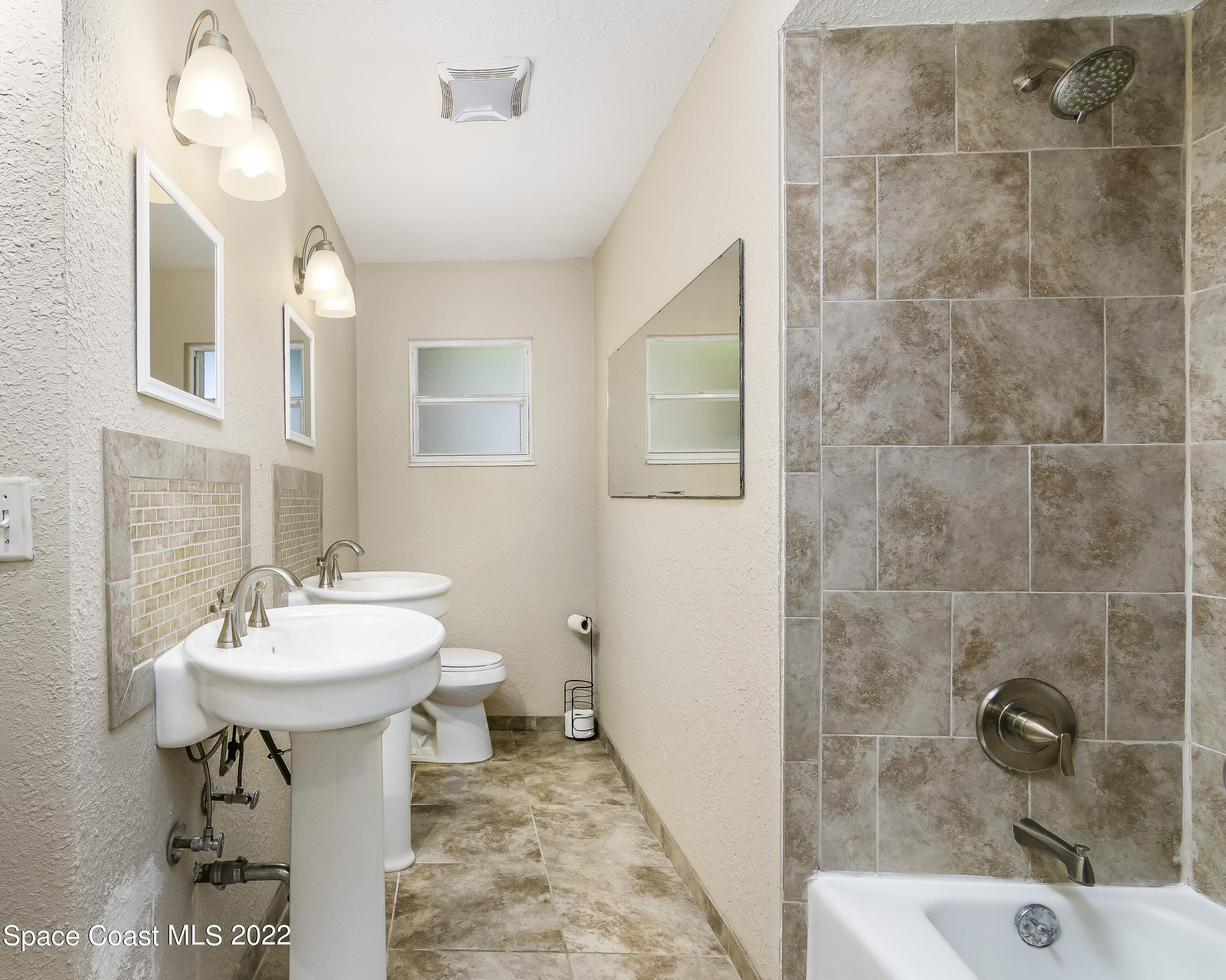 2389 Ricky Road Melbourne, FL 32935 - Photo 12 of 21 a bathroom with a sink a mirror and a shower