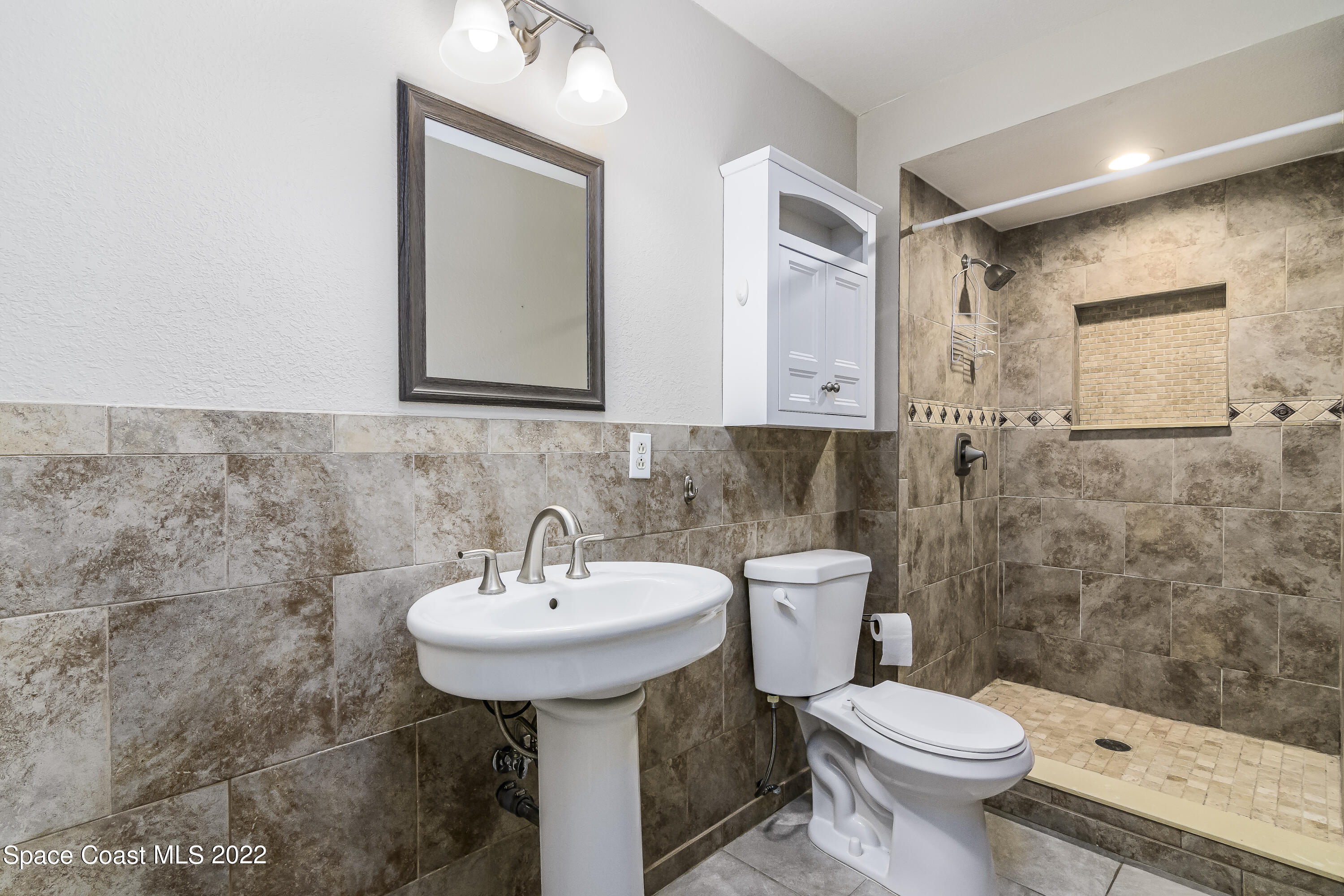 2389 Ricky Road Melbourne, FL 32935 - Photo 14 of 21 a bathroom with a sink toilet and mirror