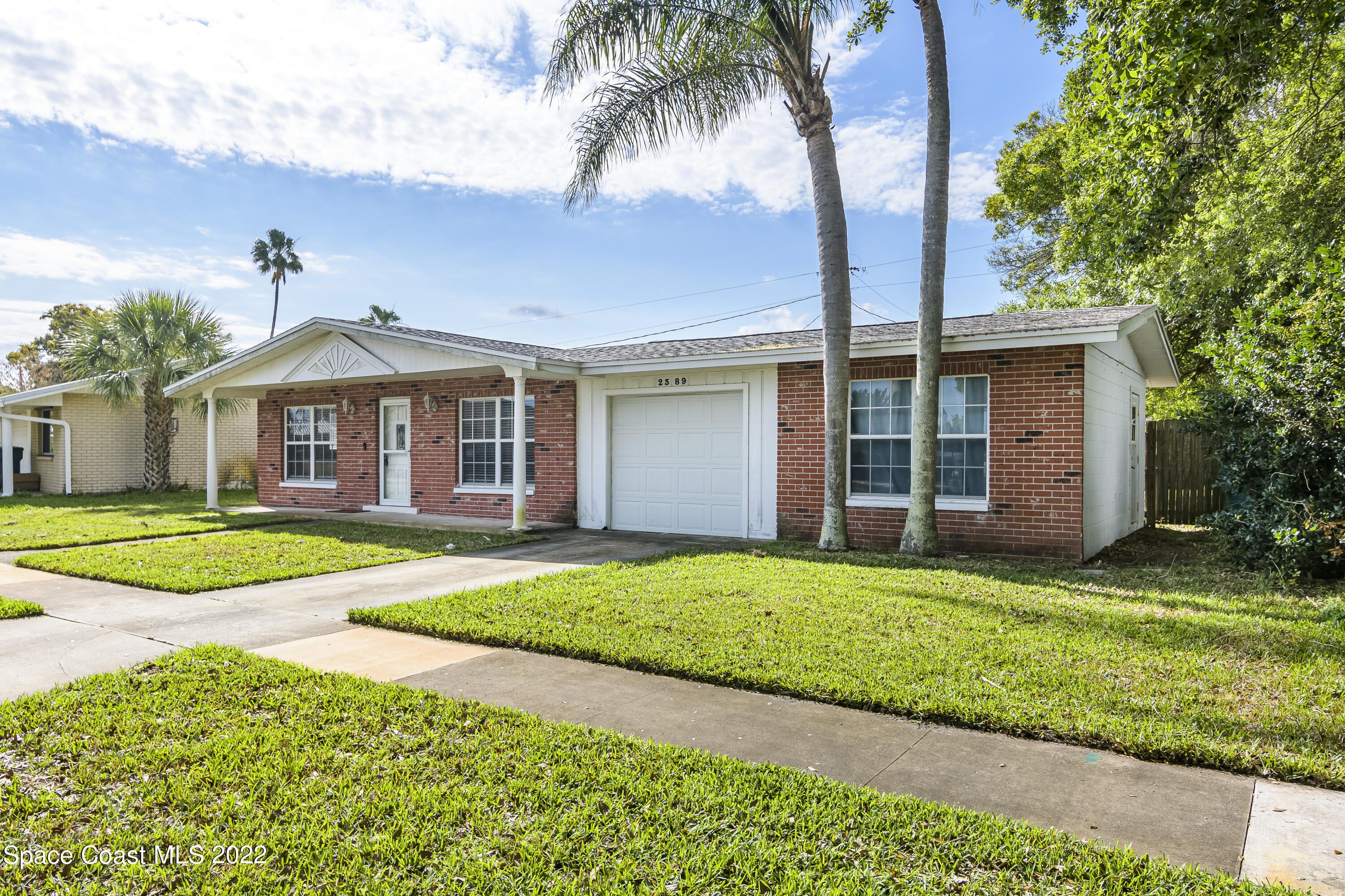 2389 Ricky Road Melbourne, FL 32935 - Photo 2 of 21 a front view of a house with a yard and garage