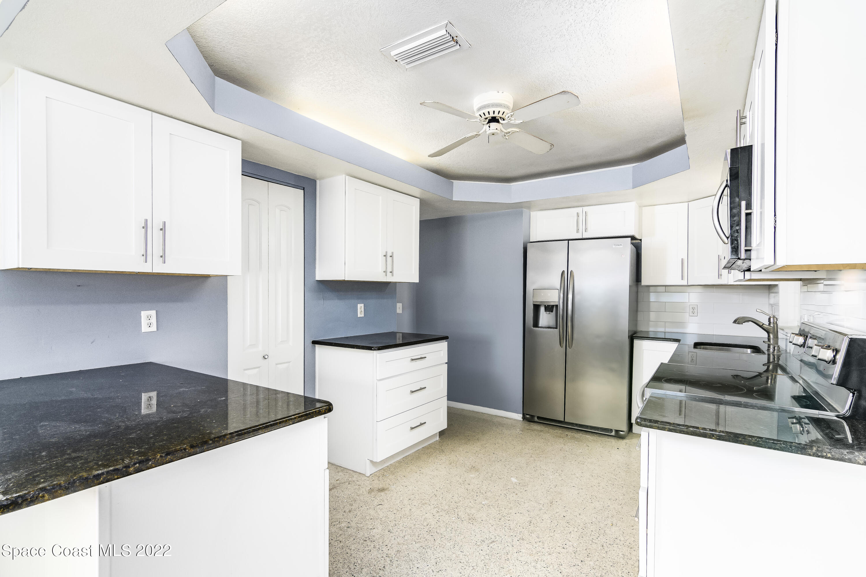 2389 Ricky Road Melbourne, FL 32935 - Photo 7 of 21 a kitchen with stainless steel appliances granite countertop a sink a stove and a refrigerator