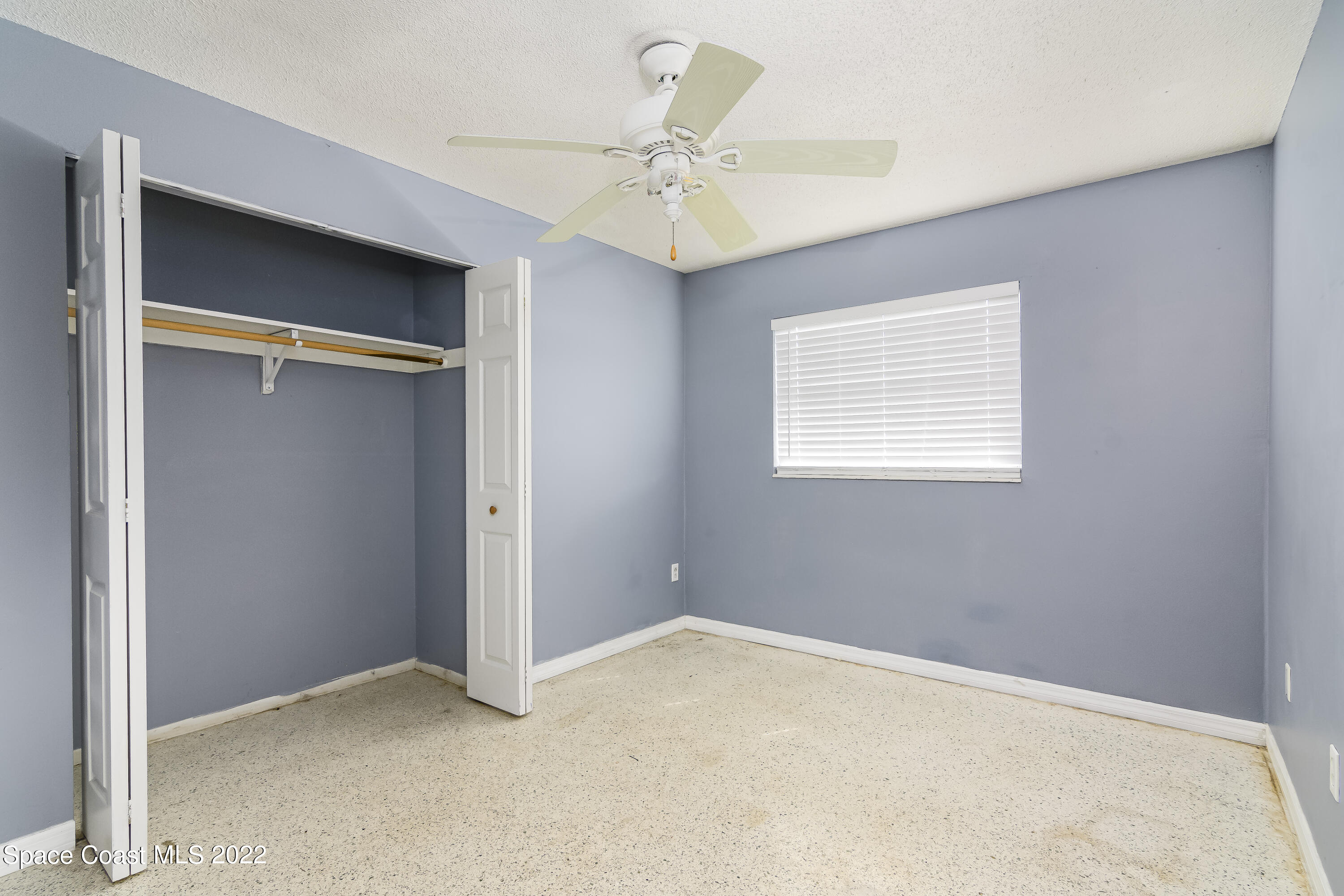 2389 Ricky Road Melbourne, FL 32935 - Photo 10 of 21 an empty room with a ceiling fan and a window