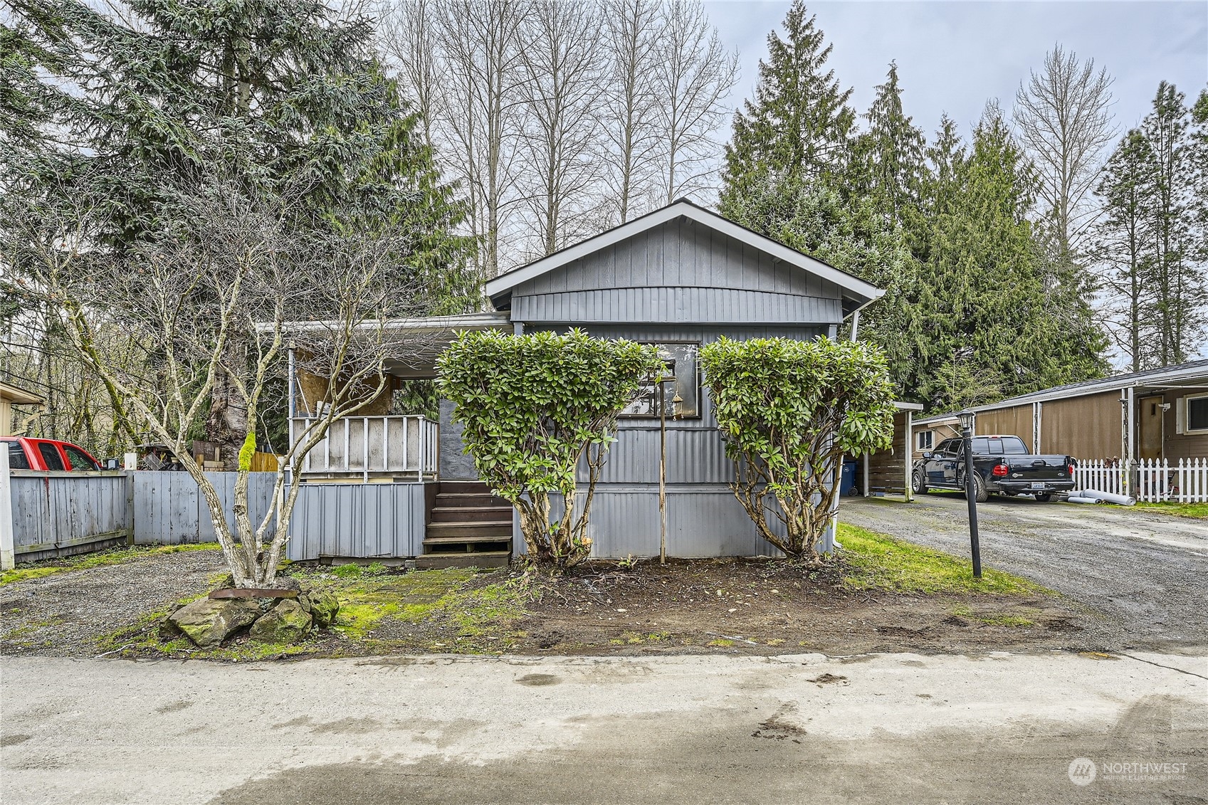 1332 192nd Street Southeast, Unit 17 Bothell, WA 98012 - Photo 2 of 24 a small barn in front of a yard with wooden fence and a bench
