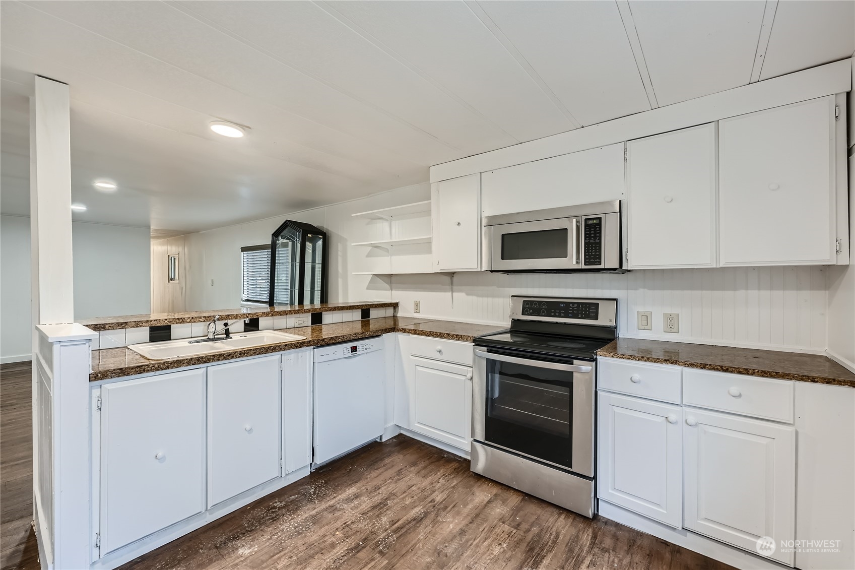 1332 192nd Street Southeast, Unit 17 Bothell, WA 98012 - Photo 9 of 24 a kitchen with granite countertop white cabinets and white appliances
