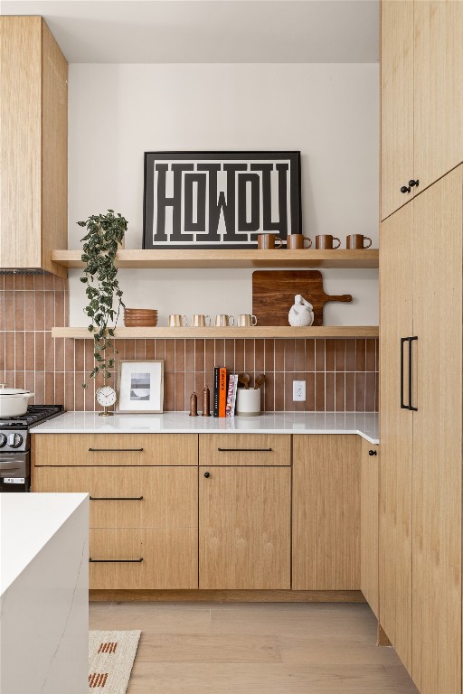 4530 Clawson Road, Unit 1 Austin, TX 78745 - Photo 12 of 24 Kitchen featuring light brown cabinetry, open shelves, tasteful backsplash, stainless steel gas stove, and light wood-style flooring