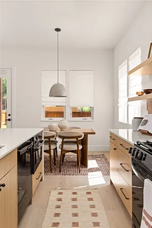 a kitchen with stainless steel appliances granite countertop a stove a sink dishwasher with a dining table and chair with wooden floor