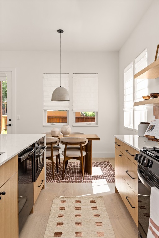 4530 Clawson Road, Unit 1 Austin, TX 78745 - Photo 13 of 24 Kitchen with black appliances, decorative light fixtures, light stone countertops, light wood-style floors, and modern cabinets