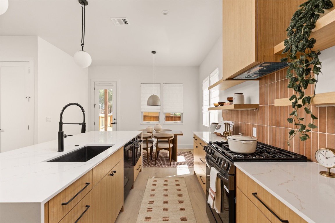 4530 Clawson Road, Unit 1 Austin, TX 78745 - Photo 14 of 24 Kitchen with light stone counters, range with gas stovetop, hanging light fixtures, and healthy amount of natural light