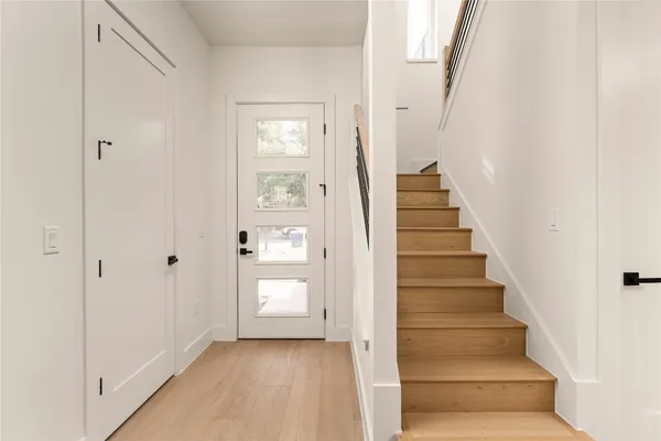 a view of a hallway with wooden floor and entryway