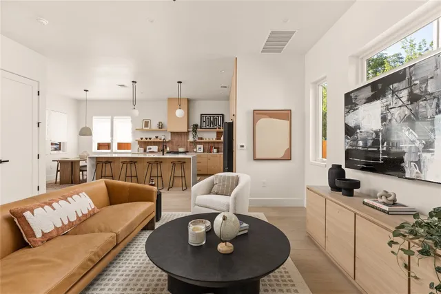 a living room with stainless steel appliances furniture and a large window