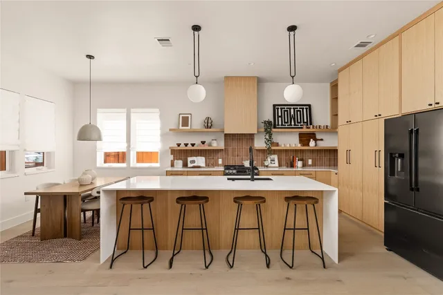 a kitchen with stainless steel appliances granite countertop a sink a stove a refrigerator and island