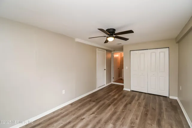 a view of a livingroom with a ceiling fan & wooden floor
