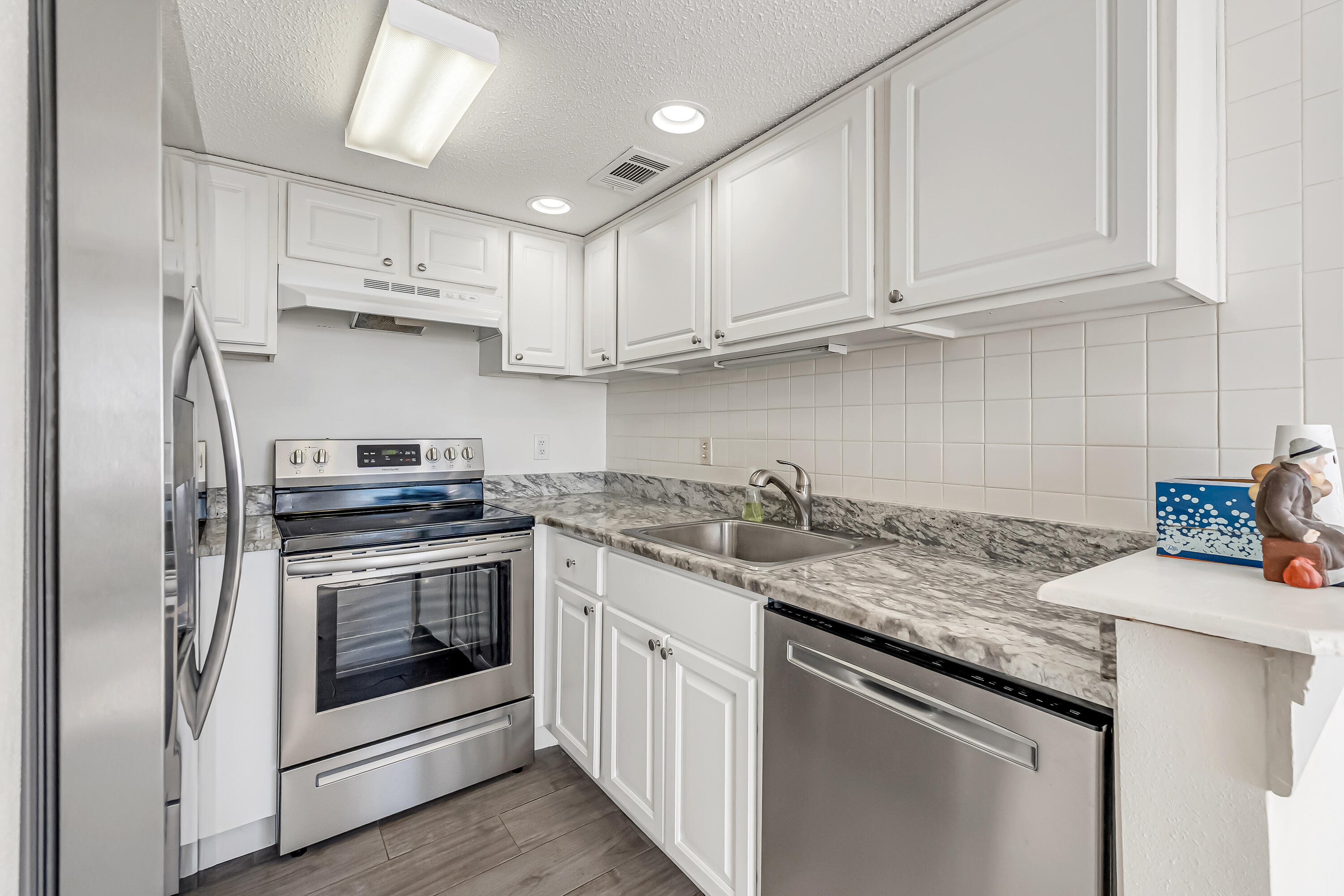 101 Old Ferry Road, Unit 20B Shalimar, FL 32579 - Photo 13 of 30 a kitchen with stainless steel appliances granite countertop a sink stove and refrigerator