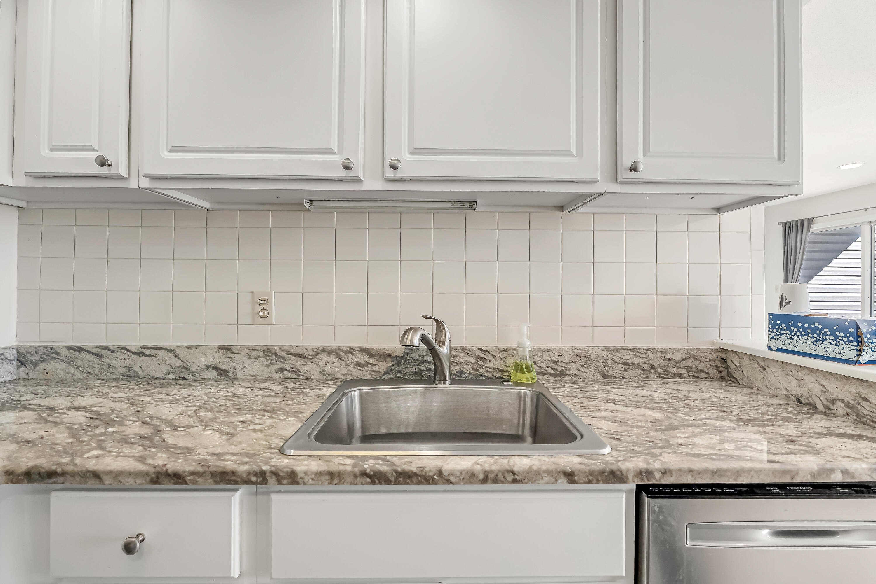 101 Old Ferry Road, Unit 20B Shalimar, FL 32579 - Photo 14 of 30 a kitchen with granite countertop a sink and white cabinets