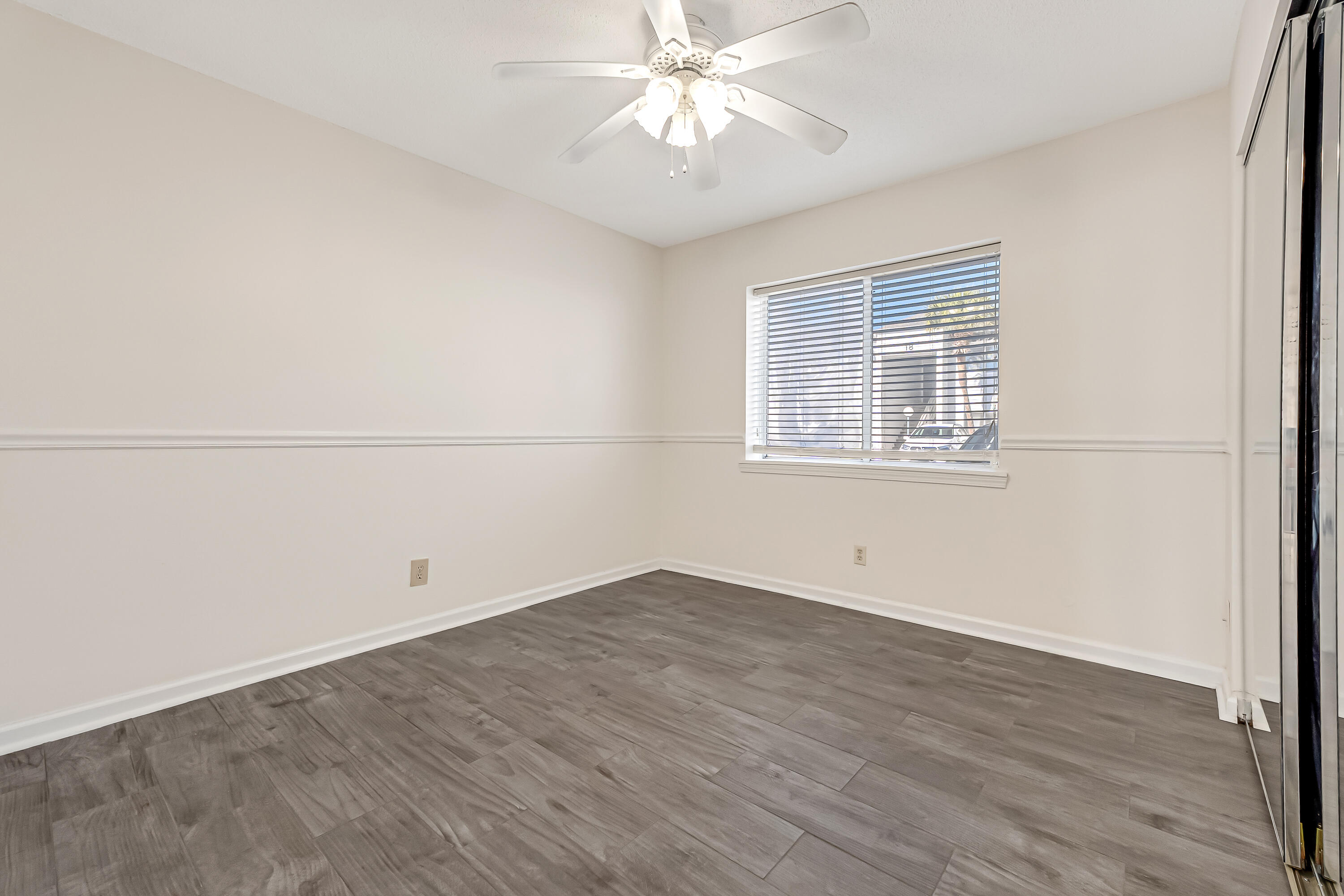 101 Old Ferry Road, Unit 20B Shalimar, FL 32579 - Photo 18 of 30 an empty room with wooden floor fan and windows