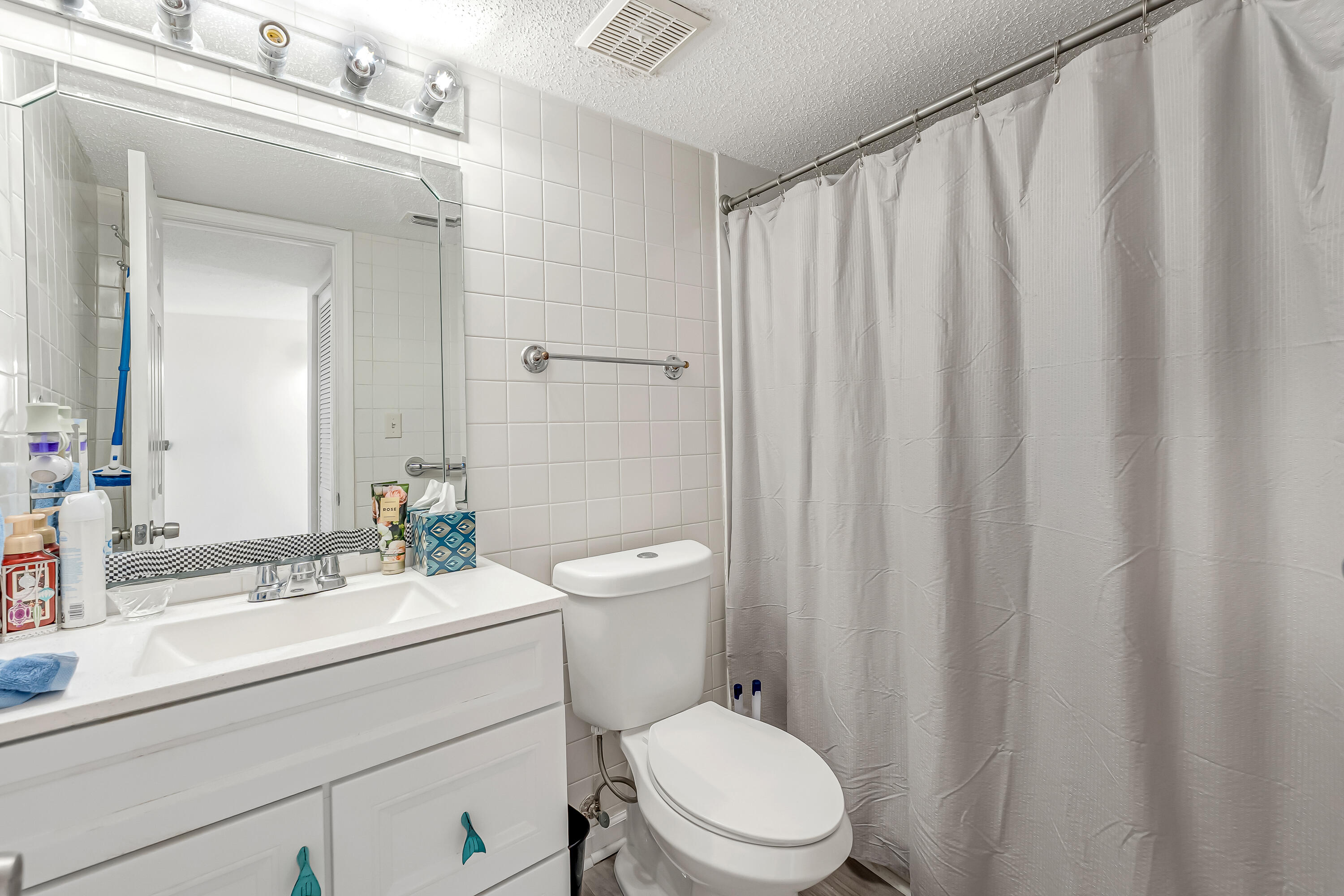 101 Old Ferry Road, Unit 20B Shalimar, FL 32579 - Photo 20 of 30 a bathroom with a sink a toilet a mirror and shower curtain