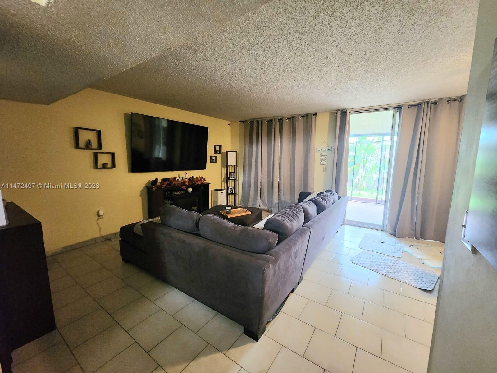 Mango Hill Hialeah, FL 33012 - Photo 2 of 18 a living room with furniture and a flat screen tv