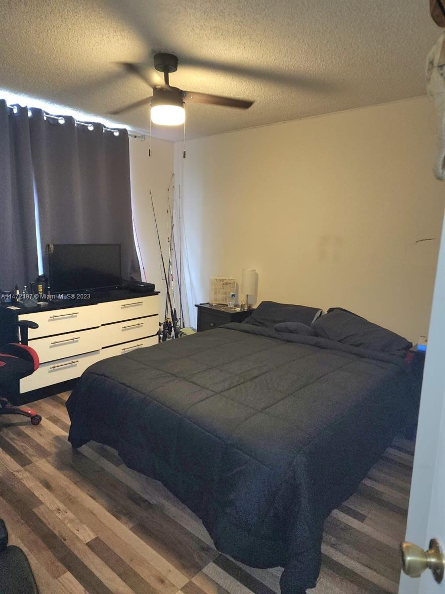 Mango Hill Hialeah, FL 33012 - Photo 9 of 18 a bedroom with a bed and a ceiling fan