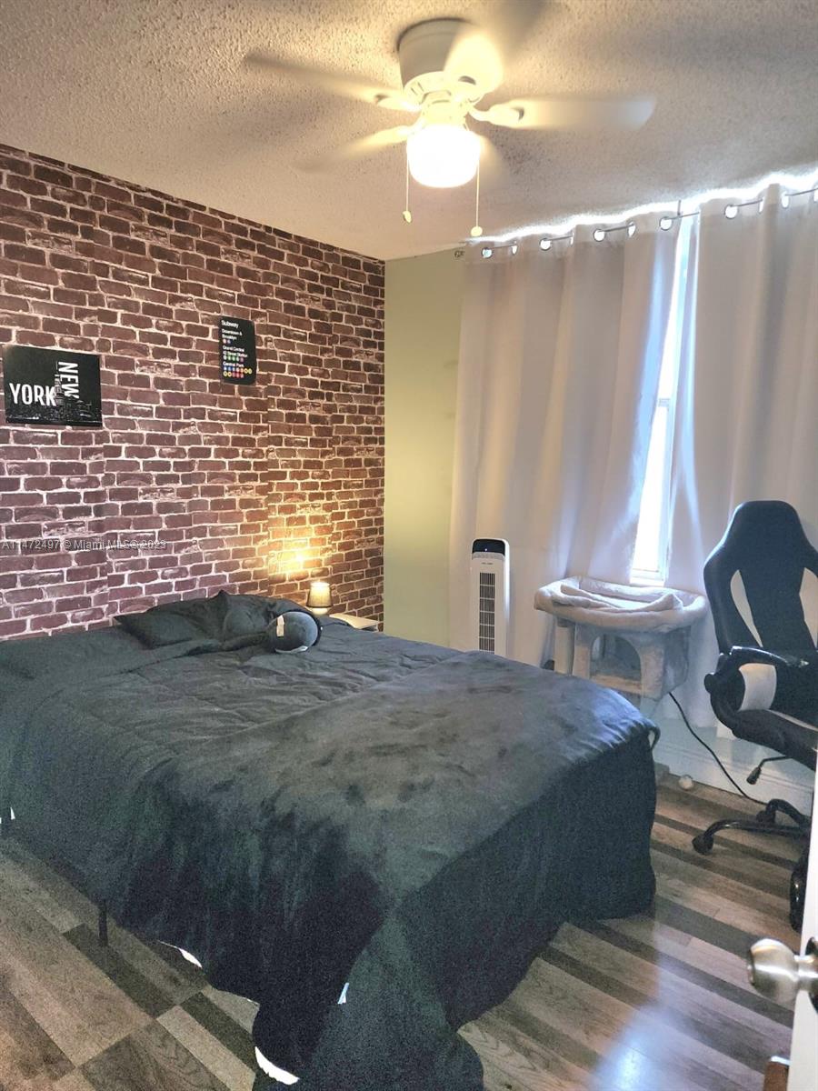 Mango Hill Hialeah, FL 33012 - Photo 10 of 18 a bedroom with a bed and a chandelier