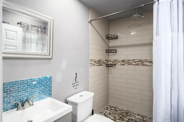 a bathroom with a sink toilet and shower