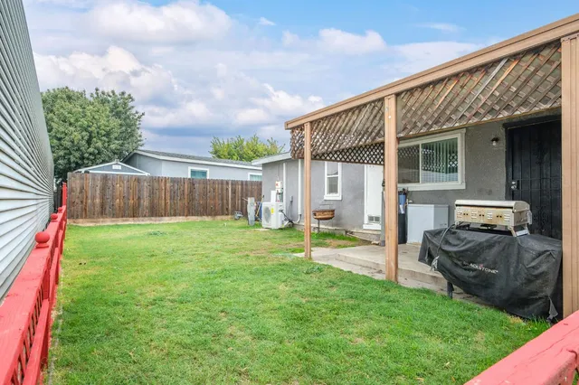 a view of a backyard with table and chairs and wooden fence