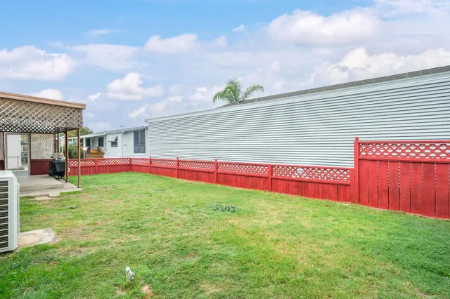 a view of yard with swimming pool and wooden fence