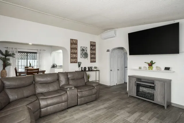 a living room with furniture a flat screen tv and a fireplace