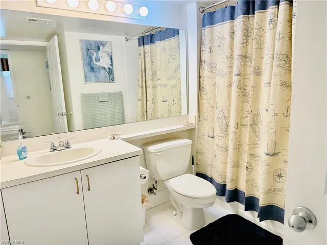 a bathroom with a sink a toilet and shower curtain