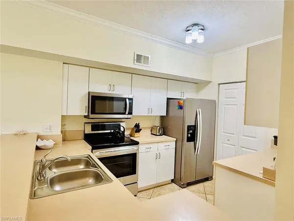 a kitchen with stainless steel appliances a stove microwave and a refrigerator