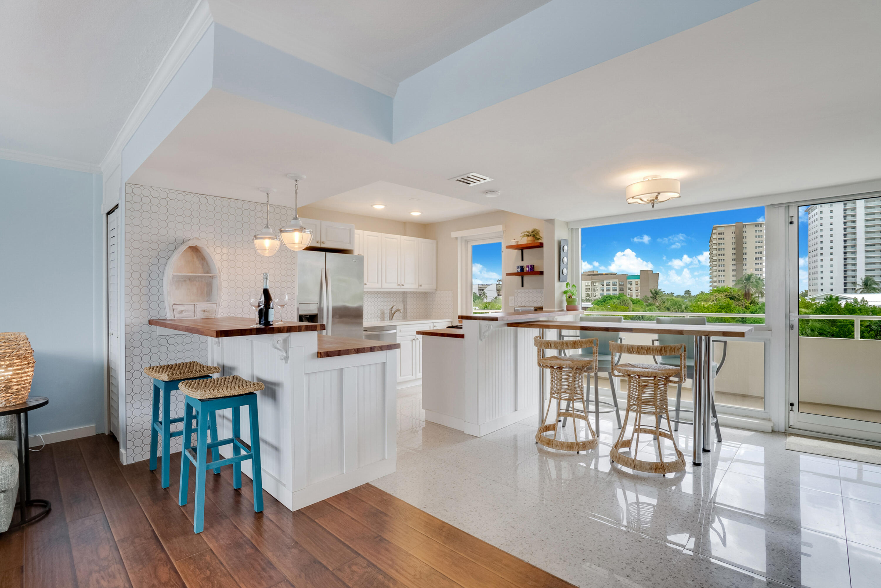201 North Riverside Drive, Unit 402 Pompano Beach, FL 33062 - Photo 22 of 30 a kitchen with white cabinets and chairs